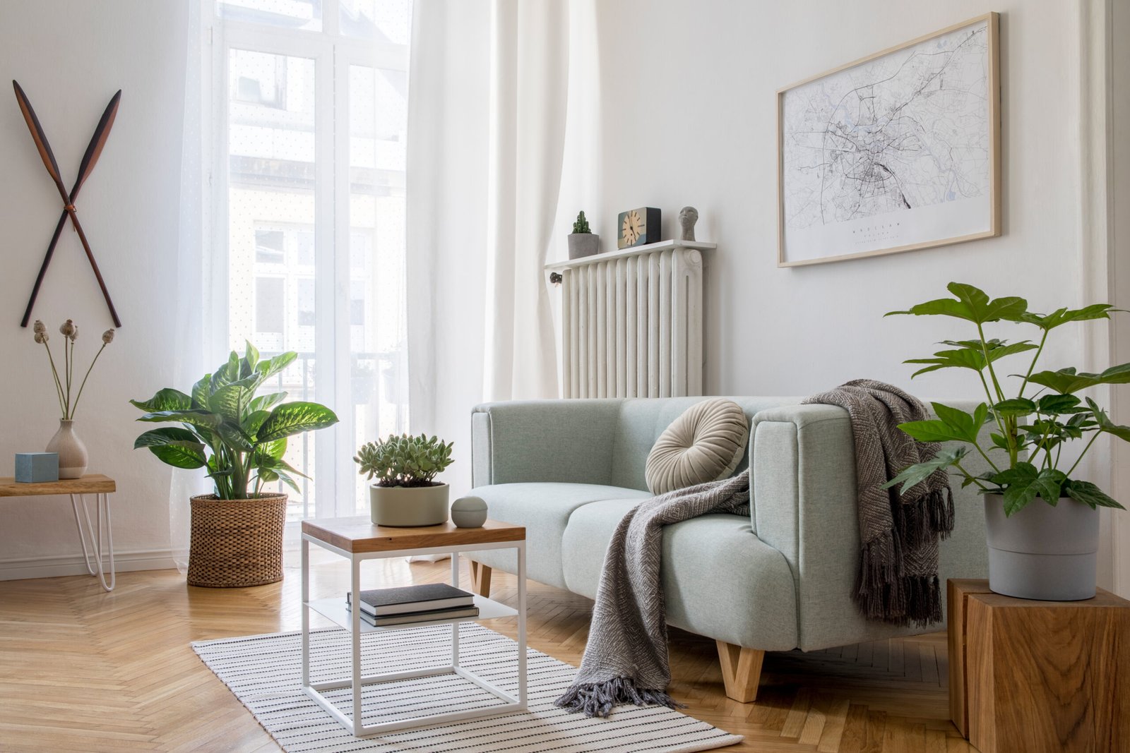 Cozy and creative composition of stylish living room interior design with mock up poster frame, green sofa, wooden furniture, plants and accessories. White walls, parquet floor. Template.