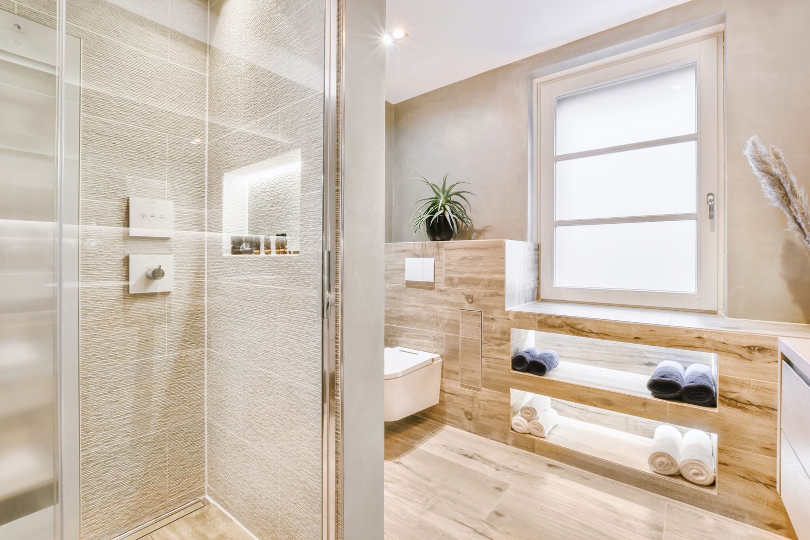 Sink base cabinet and mirror cabinet in white tiled bathroom with wall hung toilet